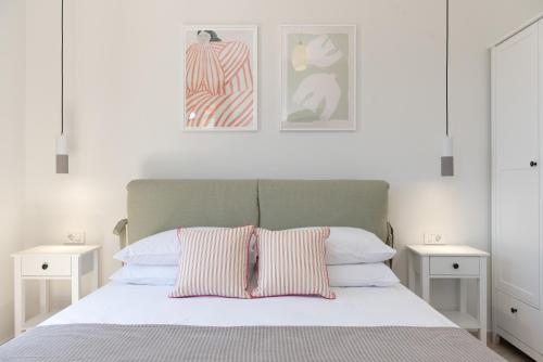 瓦西Antheon apartments的一间卧室配有一张带两个白色床头柜的床