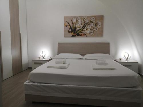 马泰拉Casa Nannina的一间卧室配有一张带2个床头柜的大型白色床