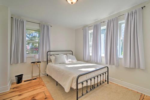 SodusCharming Sodus Point Getaway with Lake Views!的一间卧室配有一张带白色床单和窗户的床。