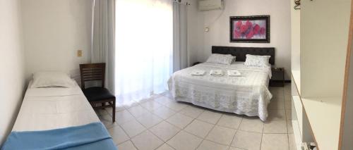 巴拉韦利亚Vila Alaide Praia Hotel的一间卧室设有一张床和一个大窗户