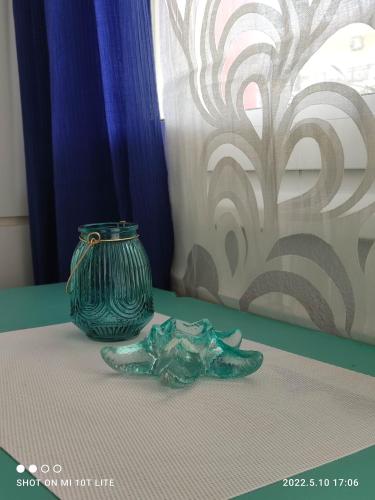 卡利塞亚-豪客迪克斯KALLITHEA Nastro Azzurro的坐在桌子顶上的绿色花瓶