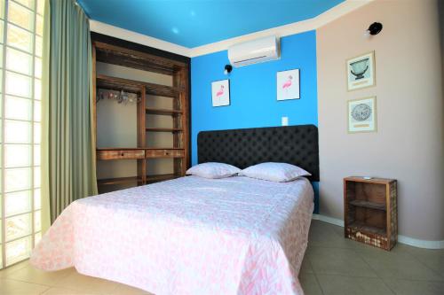 邦比尼亚斯Casa Beira Mar的一间卧室配有一张蓝色墙壁的床