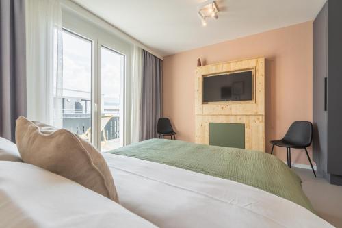 弗莱堡Arbio Hotel Freiburg的卧室配有一张大床,墙上配有电视