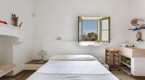 梅利萨诺Le Cernicole的白色的卧室设有床和窗户