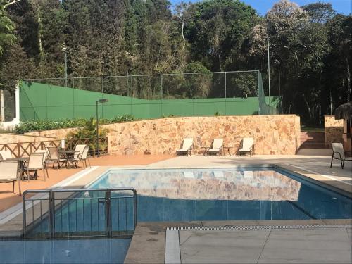 AracêCondomínio Vista Azul的一个带椅子和围栏的游泳池