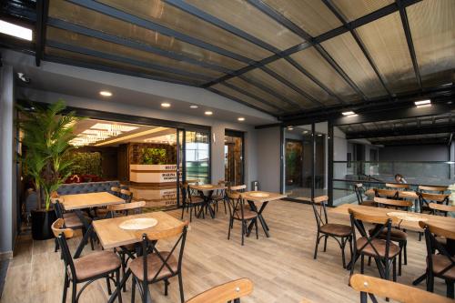 特拉布宗Marina Green Suite & Residence的餐厅设有木桌、椅子和窗户。