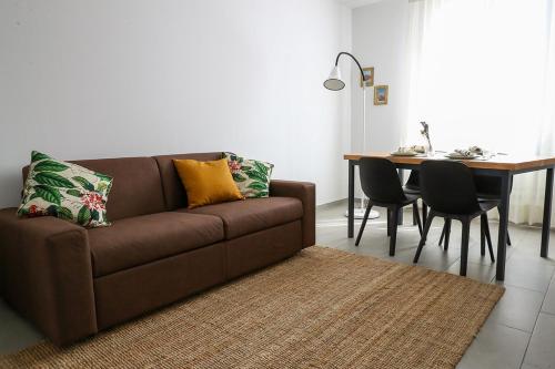 拉文纳Domus Silvana Apartments的客厅配有棕色沙发和桌子