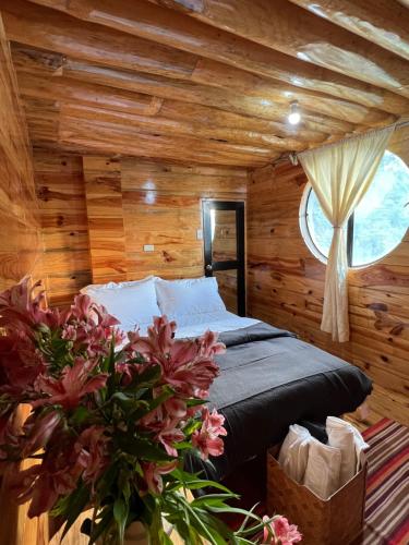 萨加达The Shire of Sagada的木制客房内的一间卧室,配有一张床