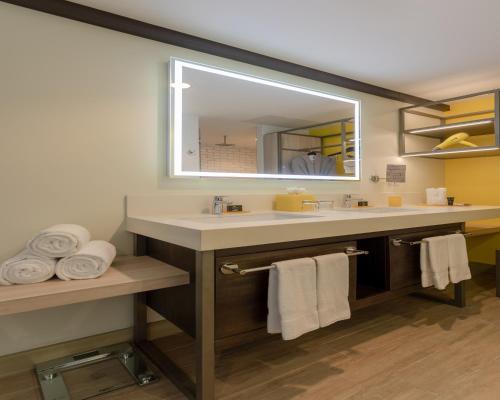 圣萨尔瓦多Hyatt Centric San Salvador的浴室配有带镜子的盥洗盆和毛巾