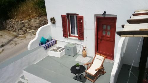 Péran TriovasálosVenduri House的白色的房子,有红色的门和椅子