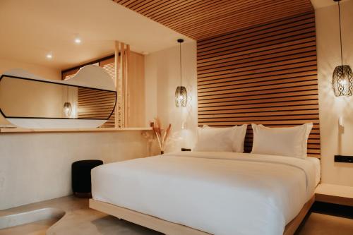帕尔加Somnus Suites Parga的卧室配有一张白色大床和镜子