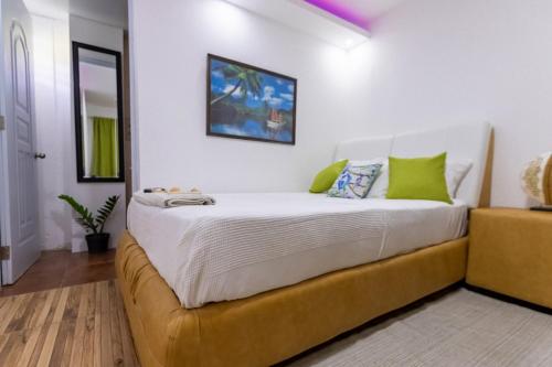 苏莎亚Room in Guest room - Nice 1br-1bt With Common Picuzzi的卧室配有带绿色枕头的大型白色床