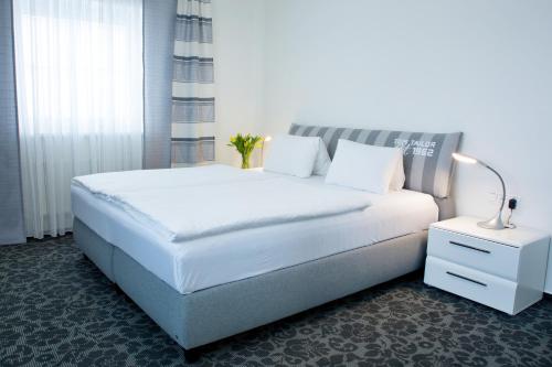 比尔森Parkhotel Plzen Congress Center的卧室配有白色大床和灯