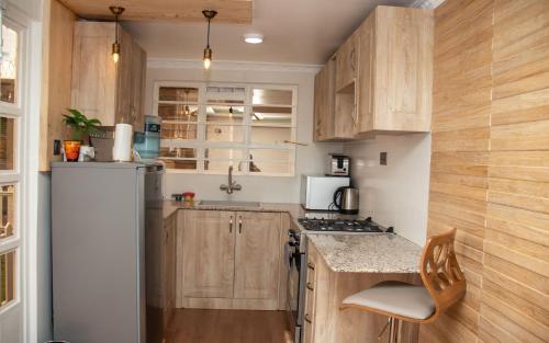 内罗毕Redhill Container House & Private Spa的厨房配有木制橱柜和冰箱。