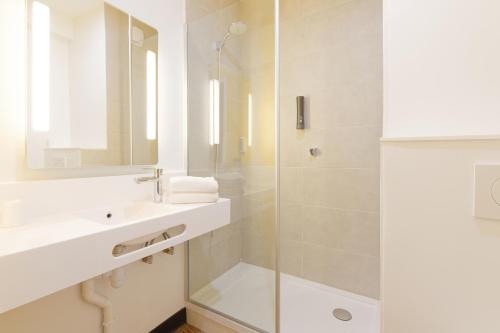 屈克B&B HOTEL Le Touquet的白色的浴室设有水槽和淋浴。