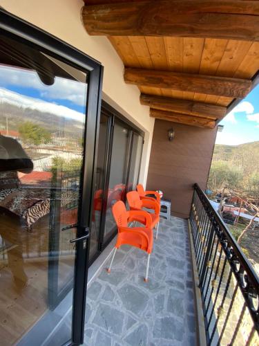 吉诺卡斯特Villa Shuaipaj的房子阳台上的一排橙色椅子