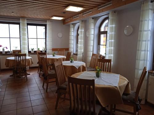 施尔奇Pension Drei Elstern的用餐室设有桌椅和窗户。