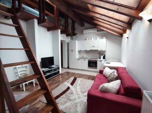 博维茨Apartments Vila Bovec的一间带红色沙发的客厅和一间厨房