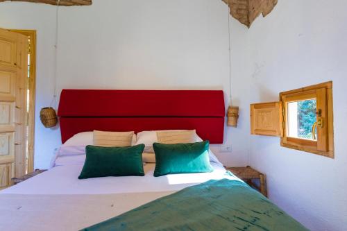圣库加特德尔瓦勒斯Hotel Torre Barcelona的一张带红色床头板和两个绿色枕头的床