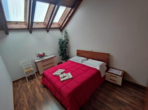 博维茨Apartments Vila Bovec的一间卧室配有红色的床和2条毛巾