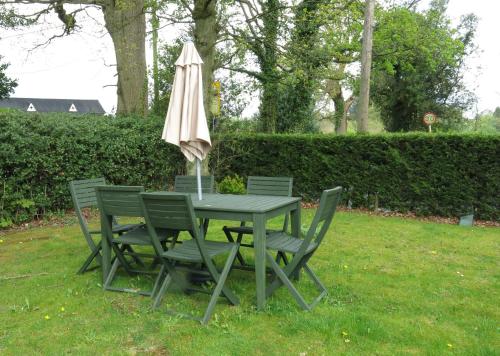 AdlingtonThe Middlewood - Luxury self contained retreat的草上带雨伞的桌椅