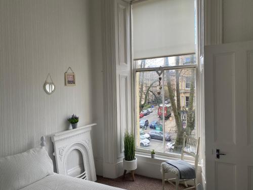 格拉斯哥Captivating apartment in glasgow westend uk的一间卧室设有一张床和一个大窗户