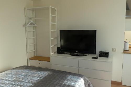 利耶帕亚Cozy Apartment at Central Market - Liepajas heart的卧室配有梳妆台上的平面电视