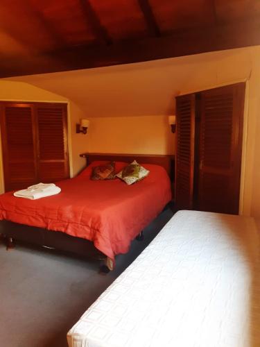 蒙特格兰德Hotel Duclout Confort Inn的一间卧室设有两张带红色床单和窗户的床。