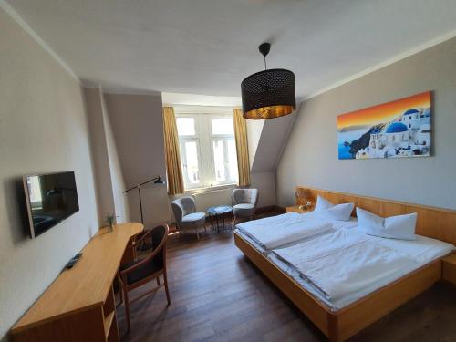 格赖茨Hotel Friedensbruecke的卧室配有一张床和一张桌子及椅子