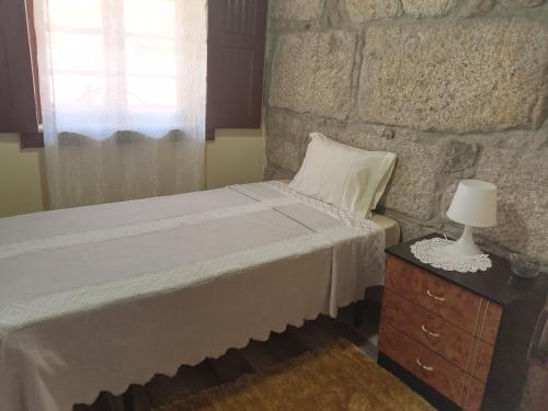 拉梅戈D. Maria São Pedro de Balsemão的一间卧室设有一张床和石墙