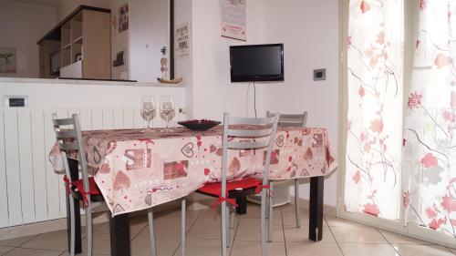 阿尔本加Bed and Breakfast da Nonna Ezia的一间带桌椅和电视的用餐室