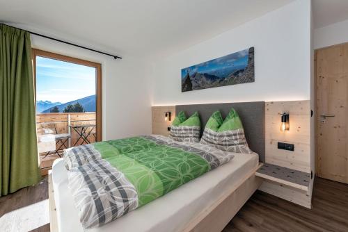 瓦勒斯Mesnerhof的一间卧室设有一张大床和一个大窗户