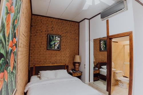 圣何塞邓恩酒店的一间卧室设有一张床和砖墙