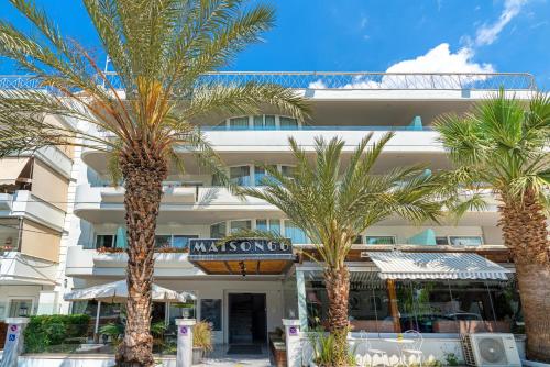 雅典Maison 66, Riviera Hotels的前面有棕榈树的酒店