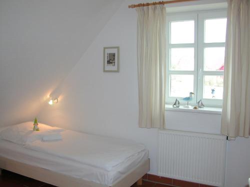 KreptitzFerienparadies Rugana C07的白色的卧室设有床和窗户