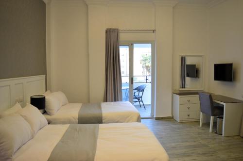 开罗Nile Villa Hotel的酒店客房配有两张床和一张书桌