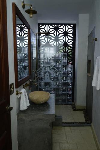 亨达Honda Colonial Magdalena Resort的一间带水槽和玻璃墙的浴室