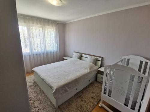 特雷比涅Apartman Andrija的白色卧室配有床和椅子