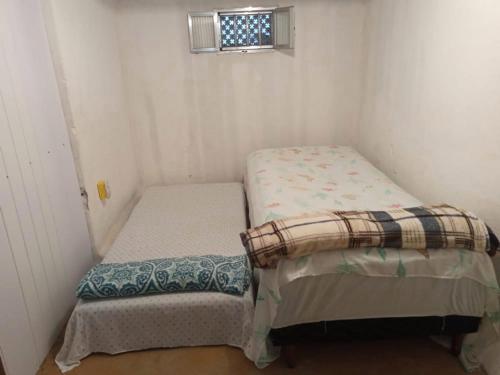 里约热内卢Espaço Aconchegante Na Ilha de Paquetá的小型客房设有两张单人床和窗户。