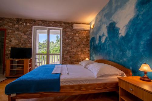德尔韦尼克Apartmani Petracie的卧室的墙上挂着一幅蓝色的大画