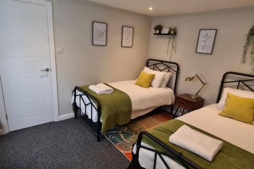 南安普敦Morris Lodge, Southampton - 1 bedroom, Free WIFI & Parking的一间卧室设有两张床,墙上配有一盏灯。