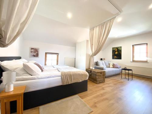 上拉德戈纳Fado Apartments Gornja Radgona的一间卧室配有一张大床和一张沙发