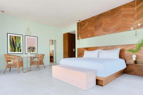 普拉亚卡门CALIXTA Hotel的一间卧室配有一张大床和一张桌子