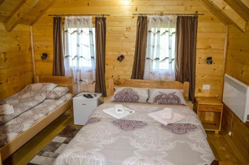 莫伊科瓦茨Tara Valley Eco Lounge的小木屋内一间卧室,配有两张床