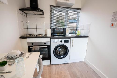 BuckinghamshireNo 02 Studio Flat Available near Aylesbury Town Station的厨房配有洗衣机和桌子