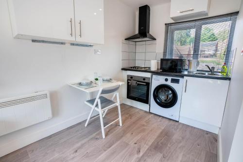 BuckinghamshireNo 02 Studio Flat Available near Aylesbury Town Station的厨房配有洗衣机和桌子