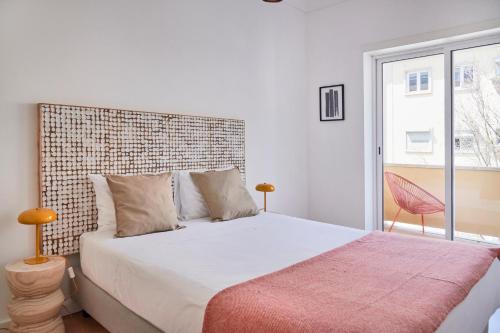 里斯本Sunset Balcony Apartment, By TimeCooler的一间卧室设有一张大床和砖墙