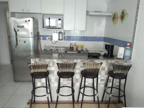 曼加拉蒂巴Porto Real Resort! Sensacional Vista Mar!的厨房配有3把吧台凳和冰箱