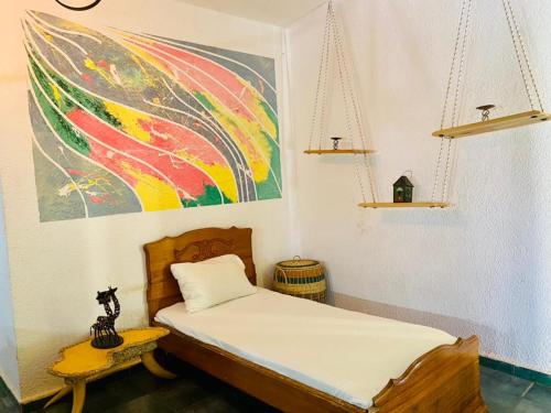 土巴迪亚劳Hotel Mimosa Airport的卧室配有一张床,墙上挂有绘画作品