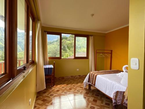 CocachimbaLa Rivera de Gocta的一间卧室设有一张床和两个窗户。
